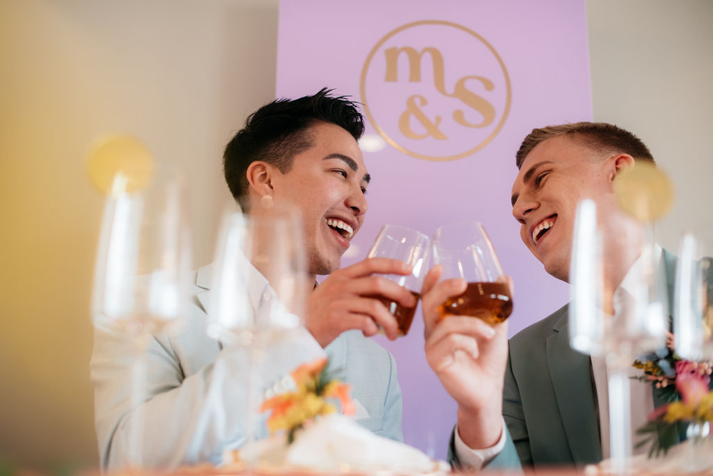 Interracial gay couple toasting during wedding