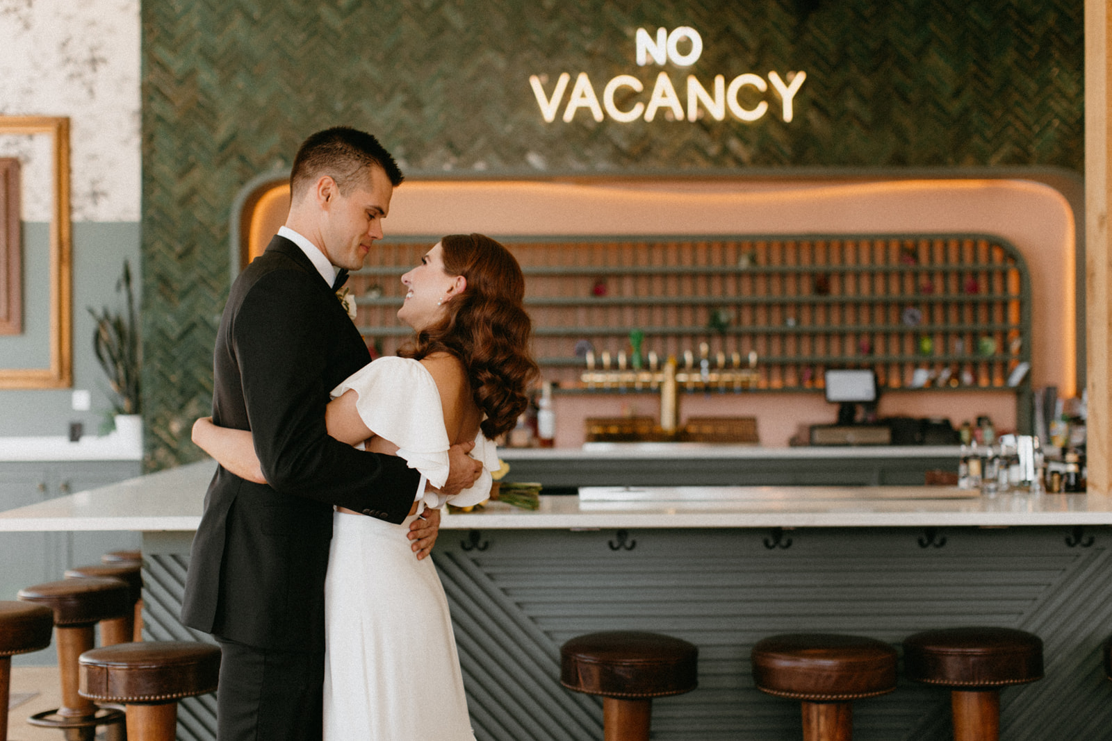 Couple in front of vintage no vacancy sign
