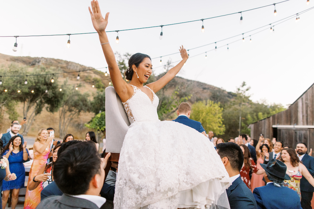 Bride being lifted on chair during Jewish reception