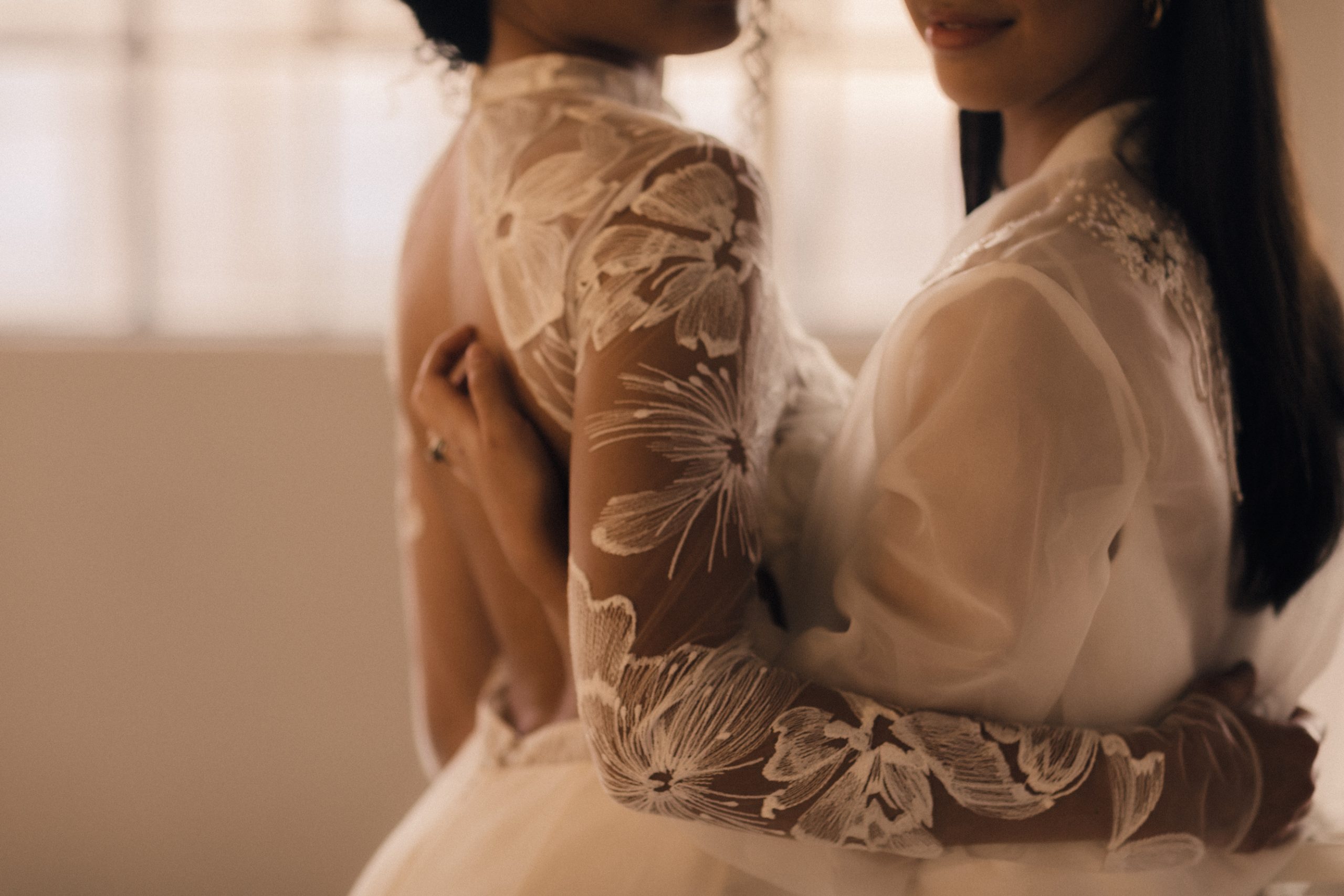 Brides hugging, dress details shown