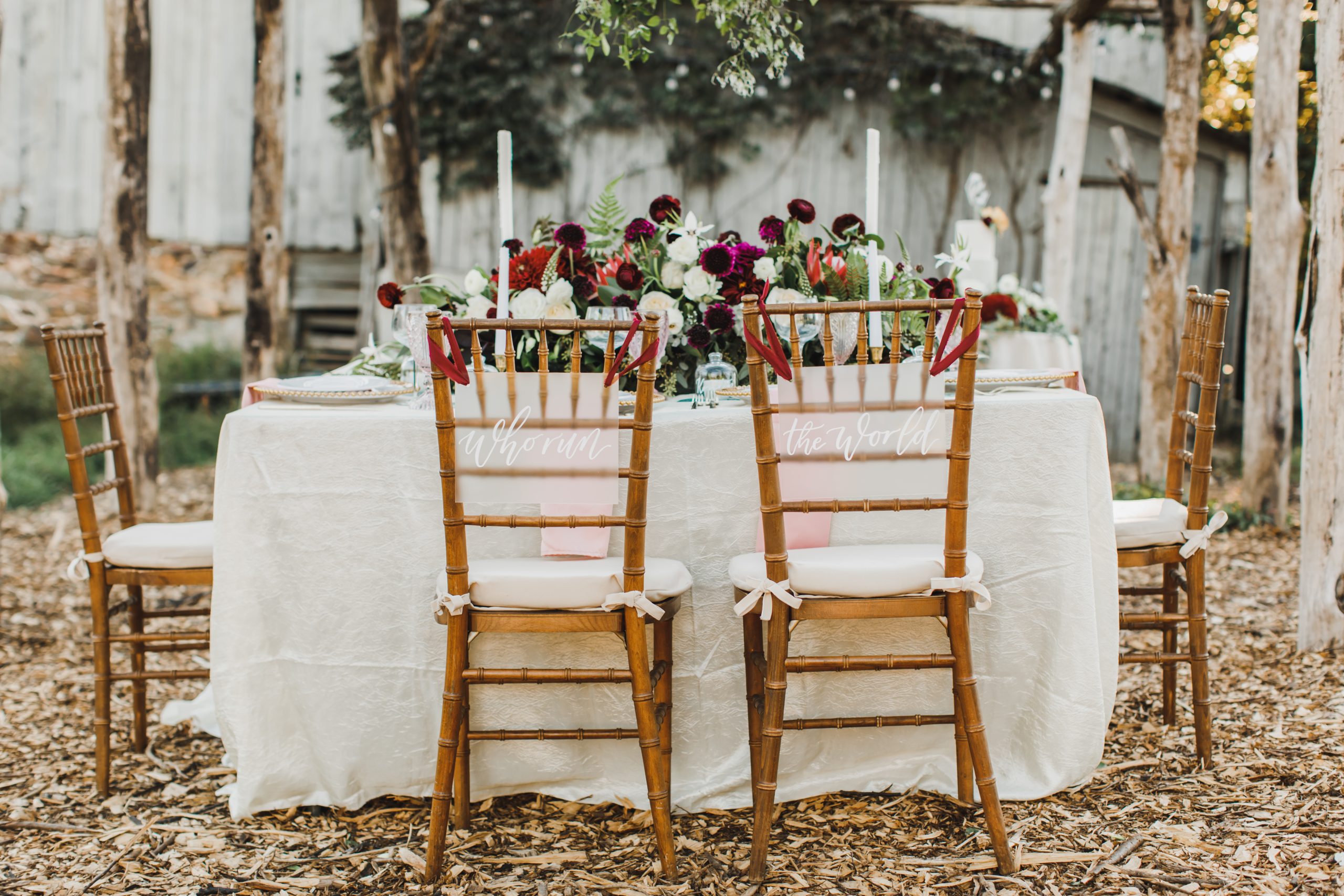 Sweetheart table chairs with signs that say 'who run the world'