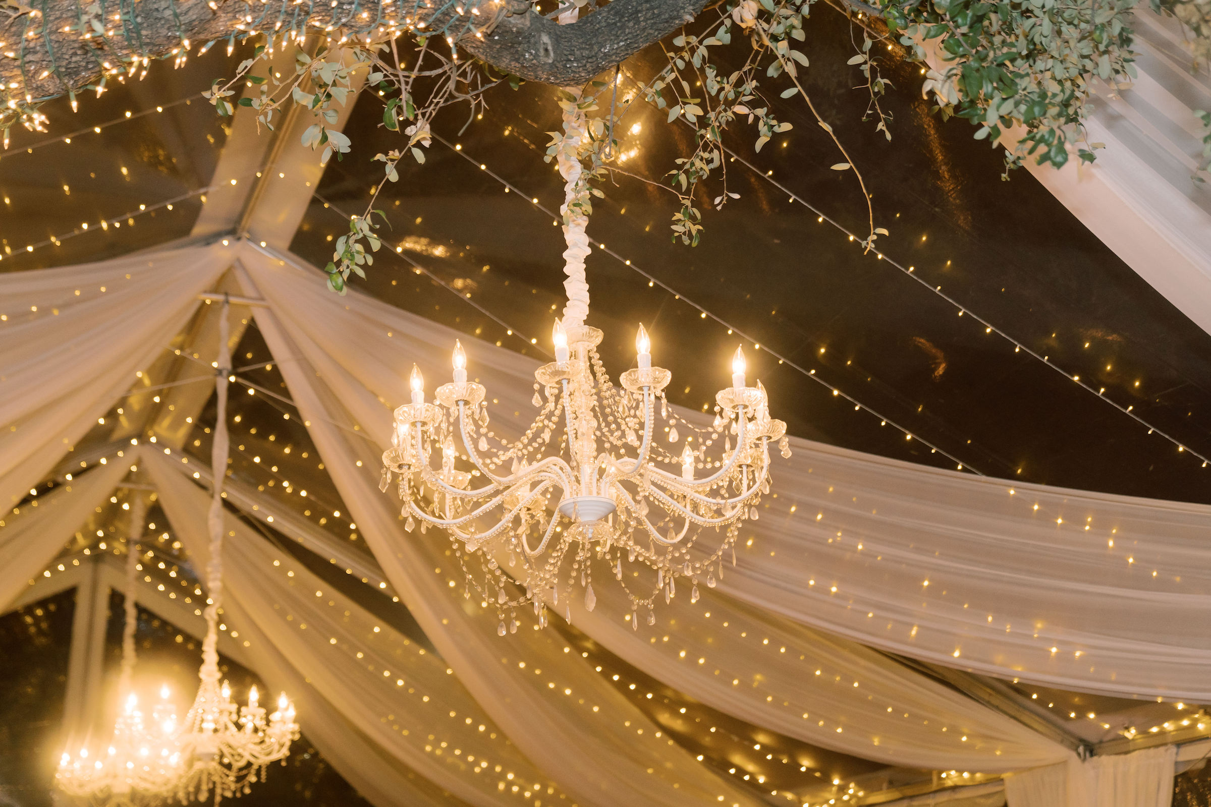 glowing chandelier hung amongst tapestries 