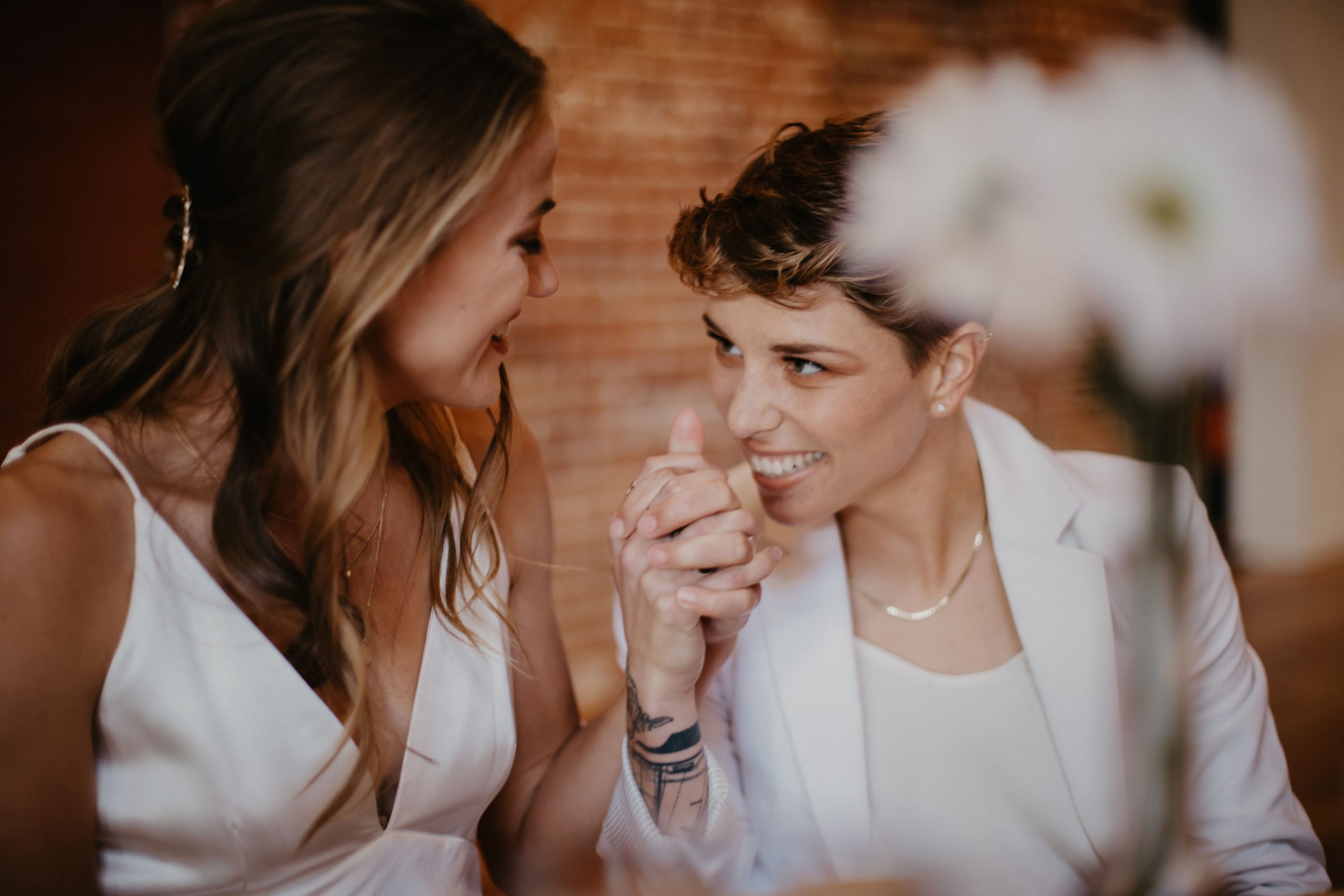 couple smiling at each other behind flowers
