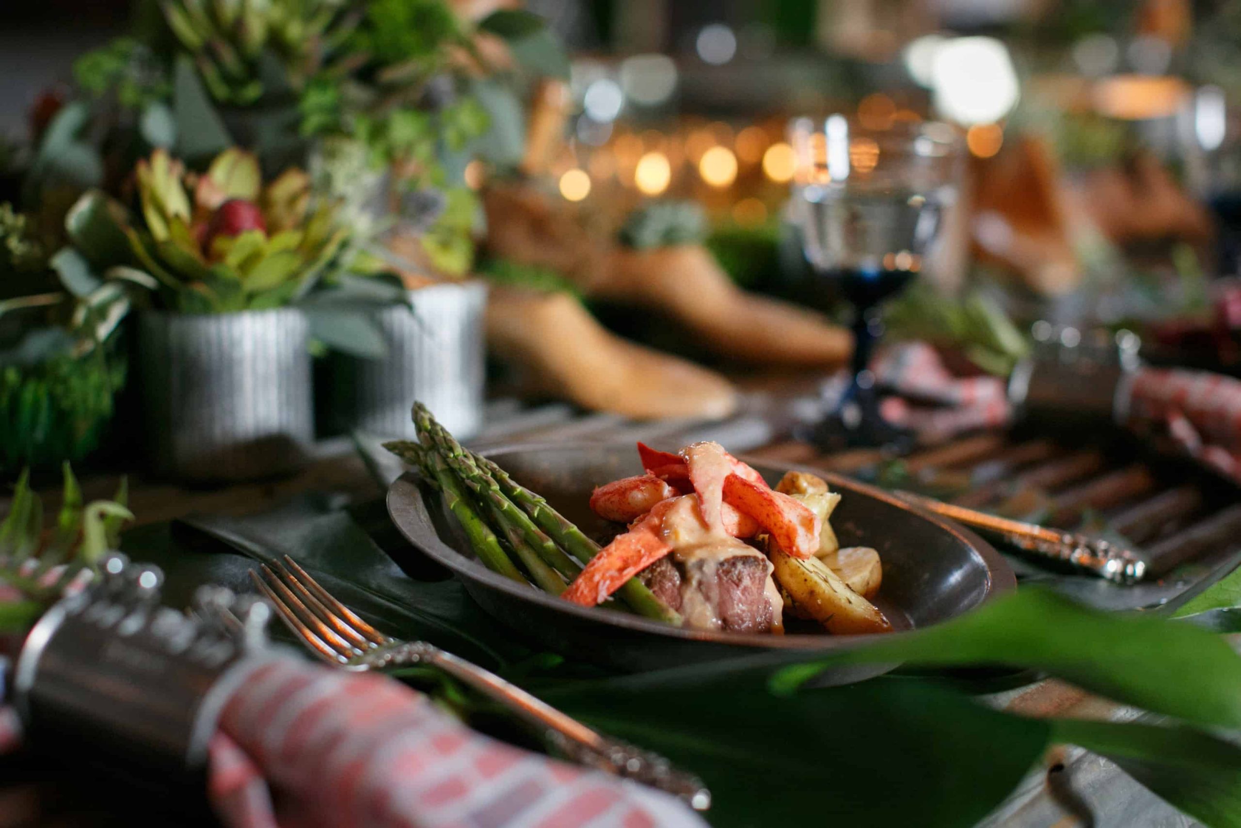 Tablescape with a dish of lobster, potatoes, and veggies 