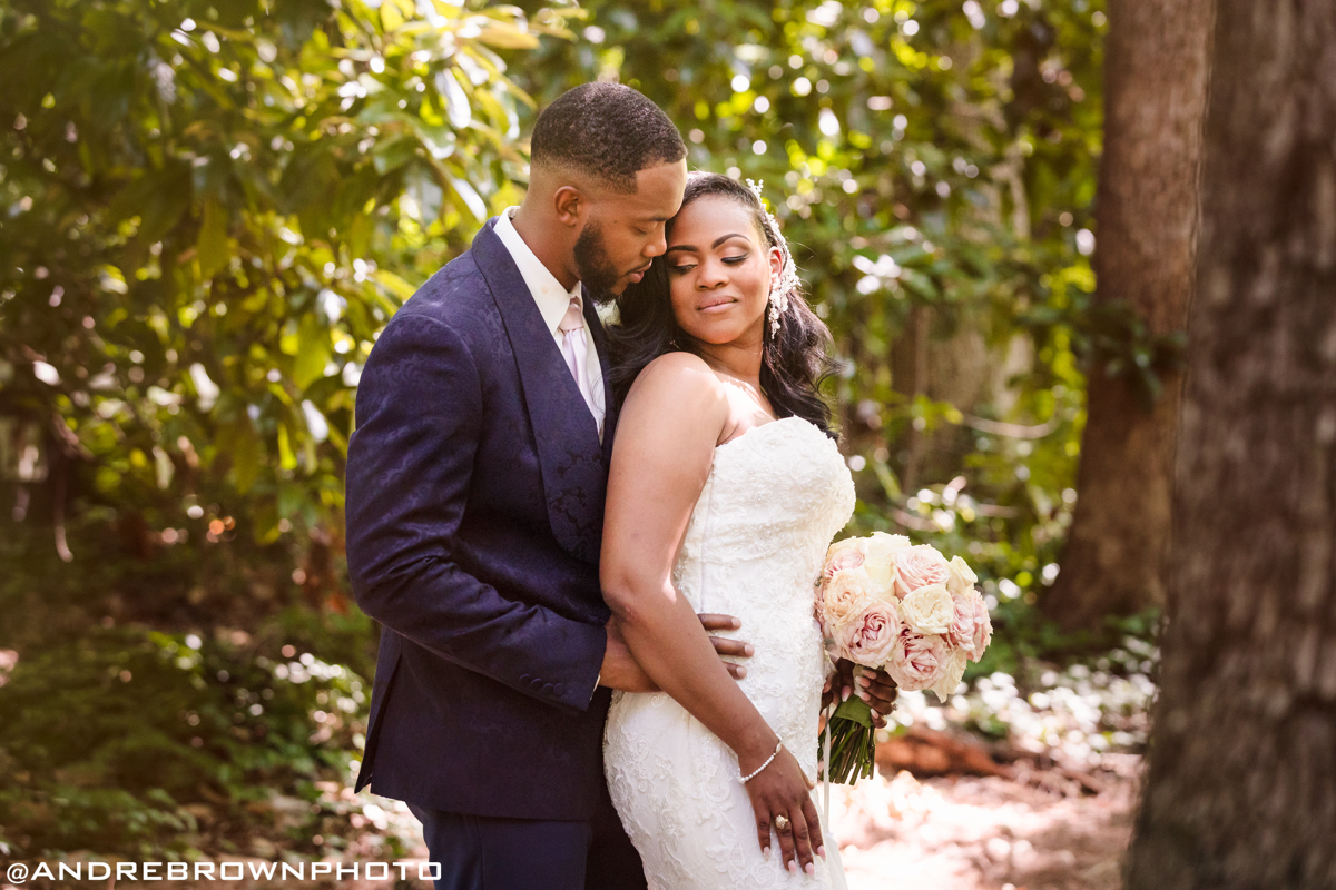 couple with forest backdrop looking lovingly at one another in wedding attire