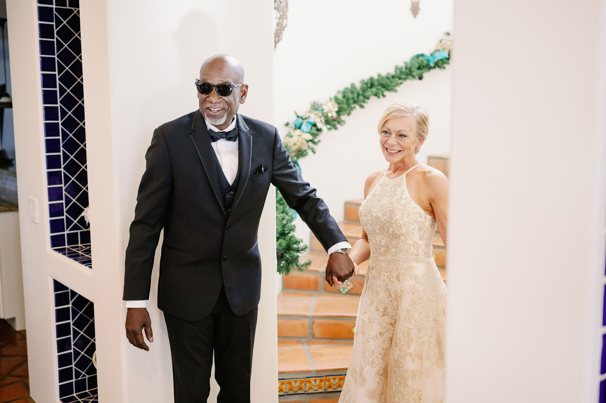 Kim and John in wedding attire coming down the stairs