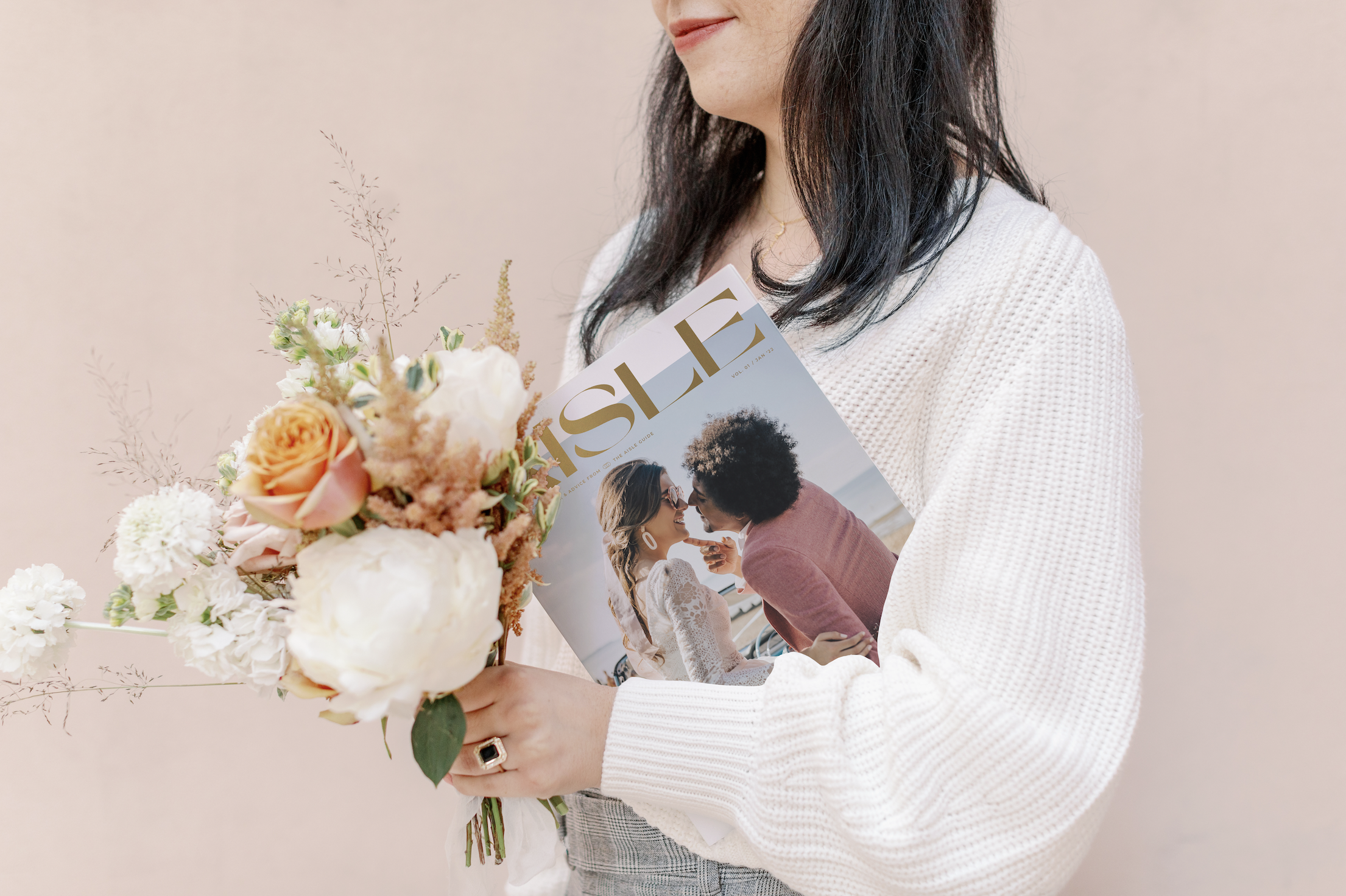 Woman holding flowers and The Aisle magazine