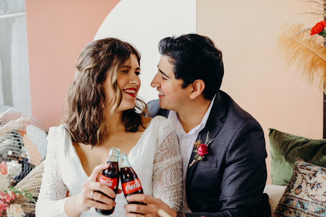 Couple looking at each other holding Coca Cola bottles