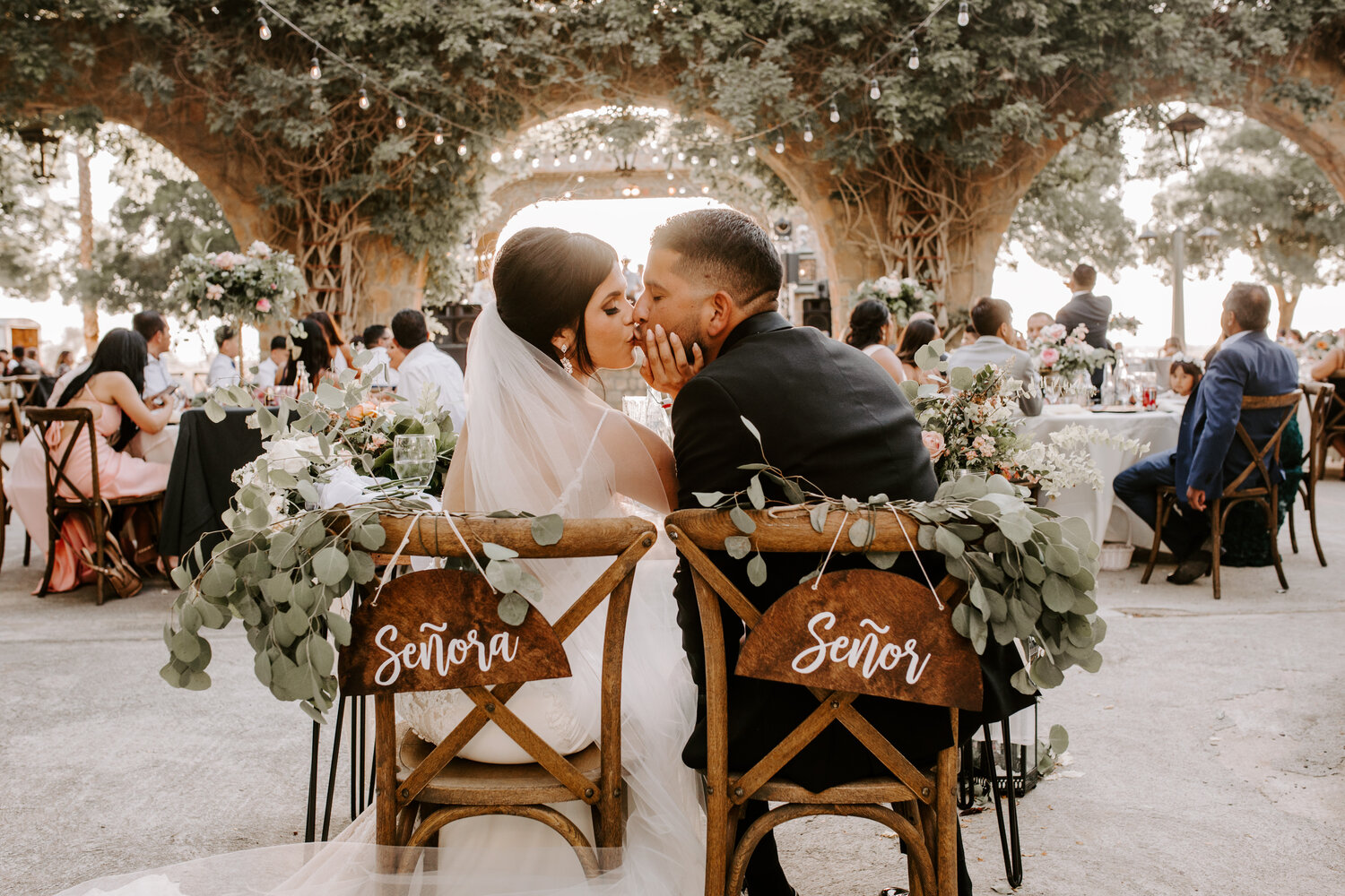Couple kissing, sitting at sweetheart table