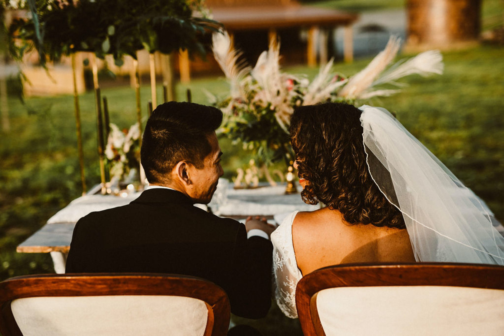couple sitting at sweetheart table, staring at one another in marital bliss