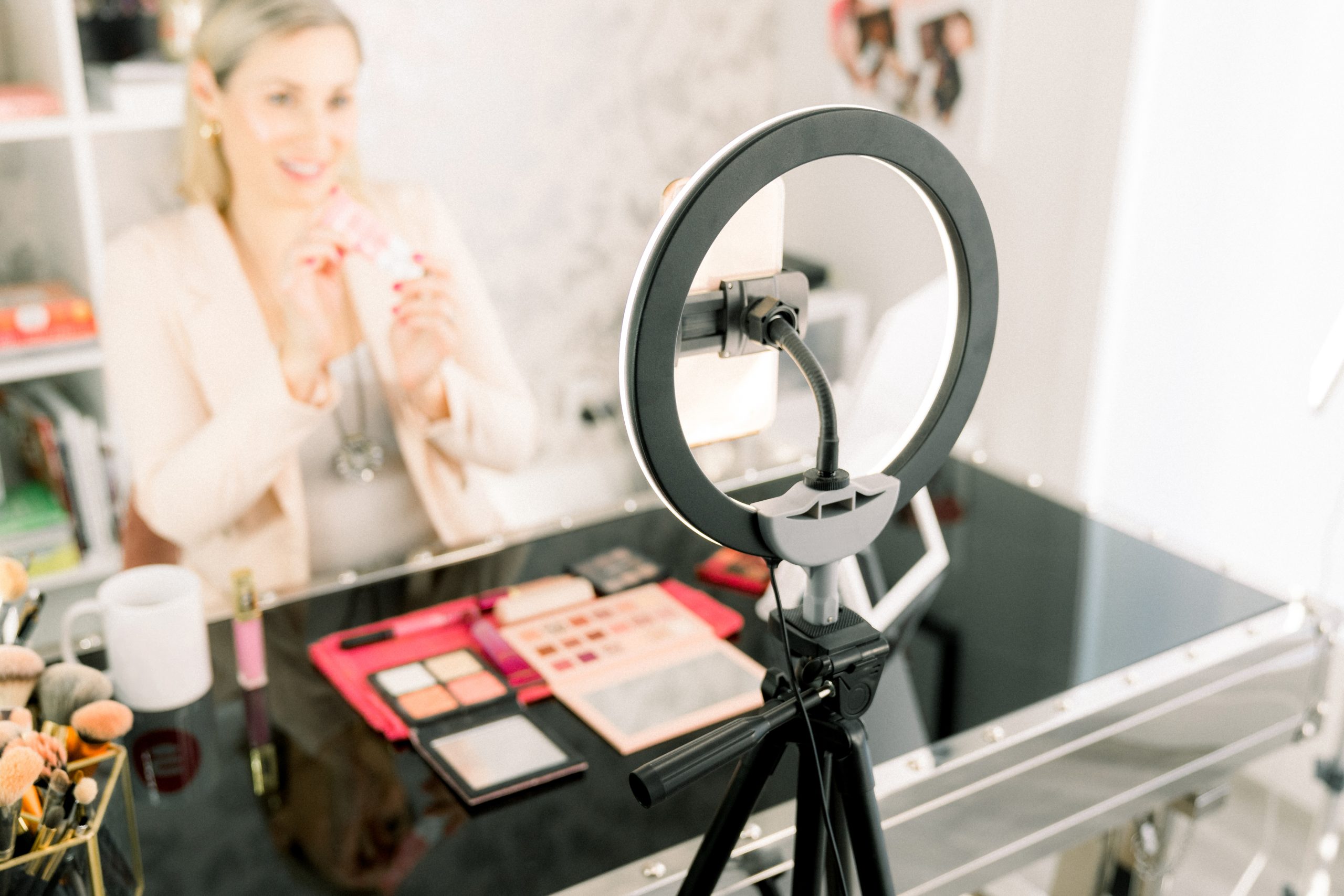 A woman filming a video in front of a ring light