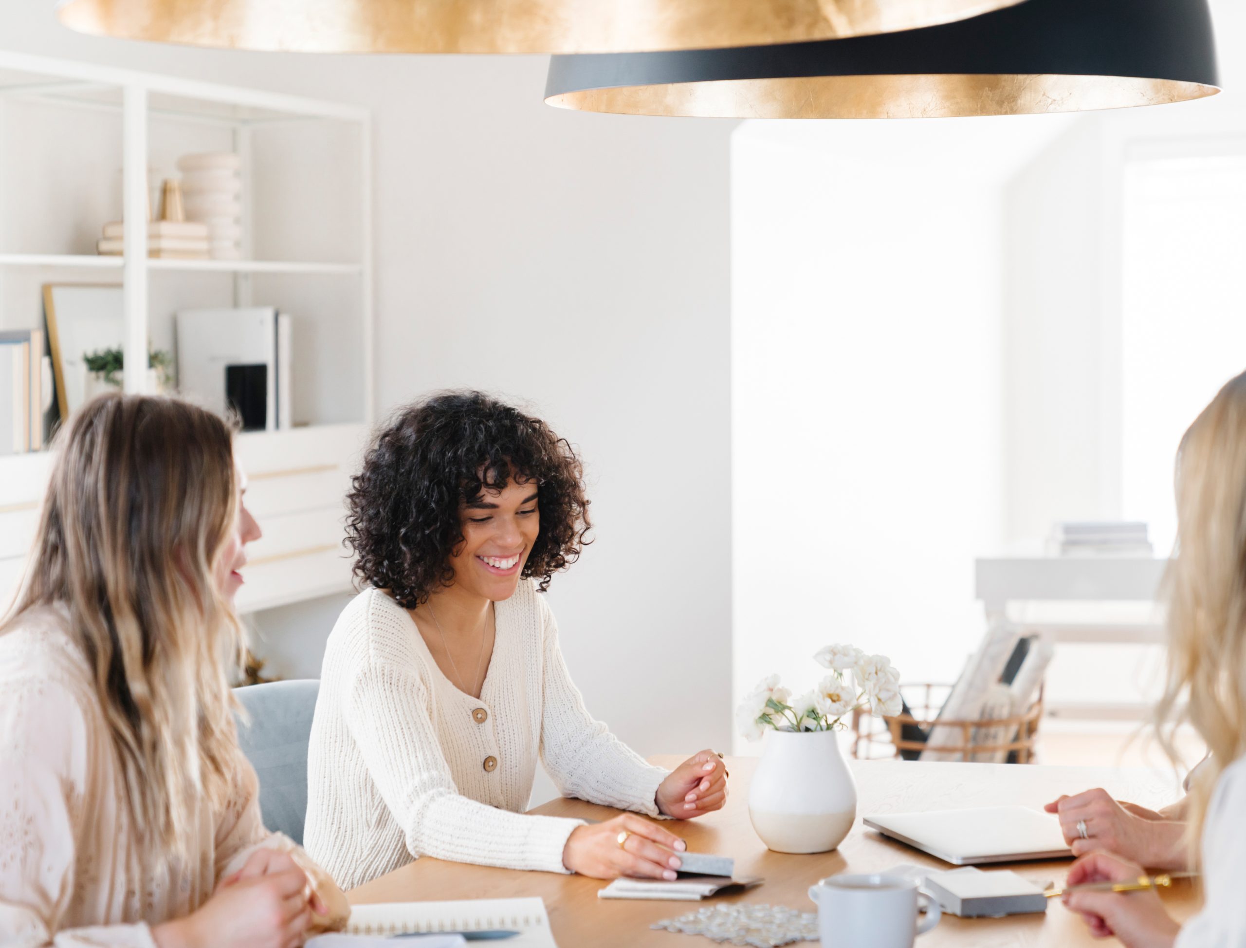 Women sitting at a table working and talking