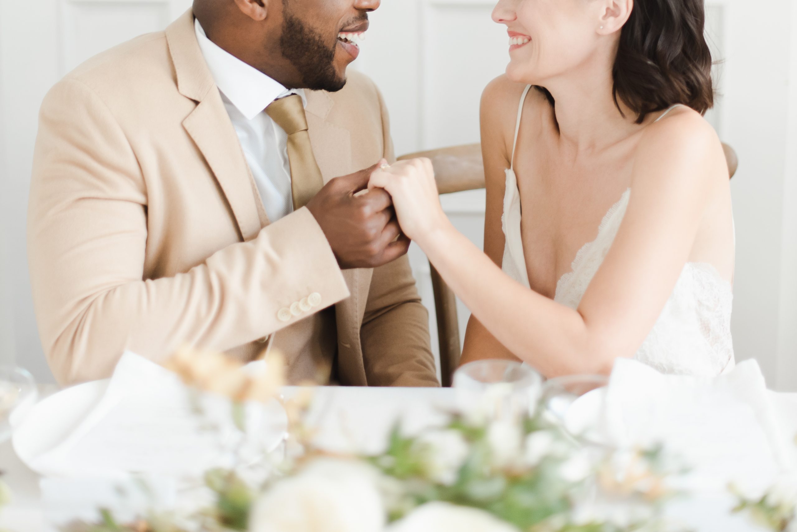 Marriers looking at each other at a table with florals.