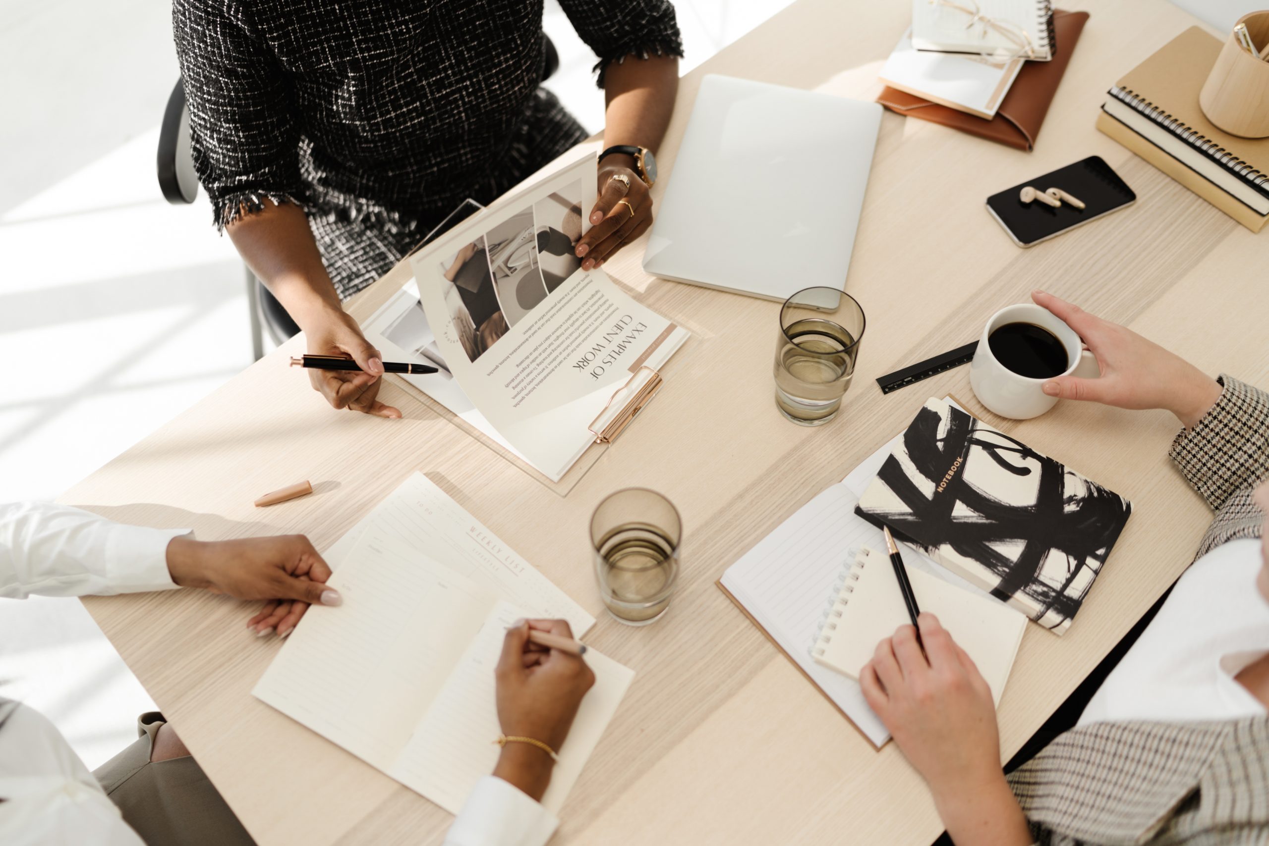women working at a table with papers on the desk