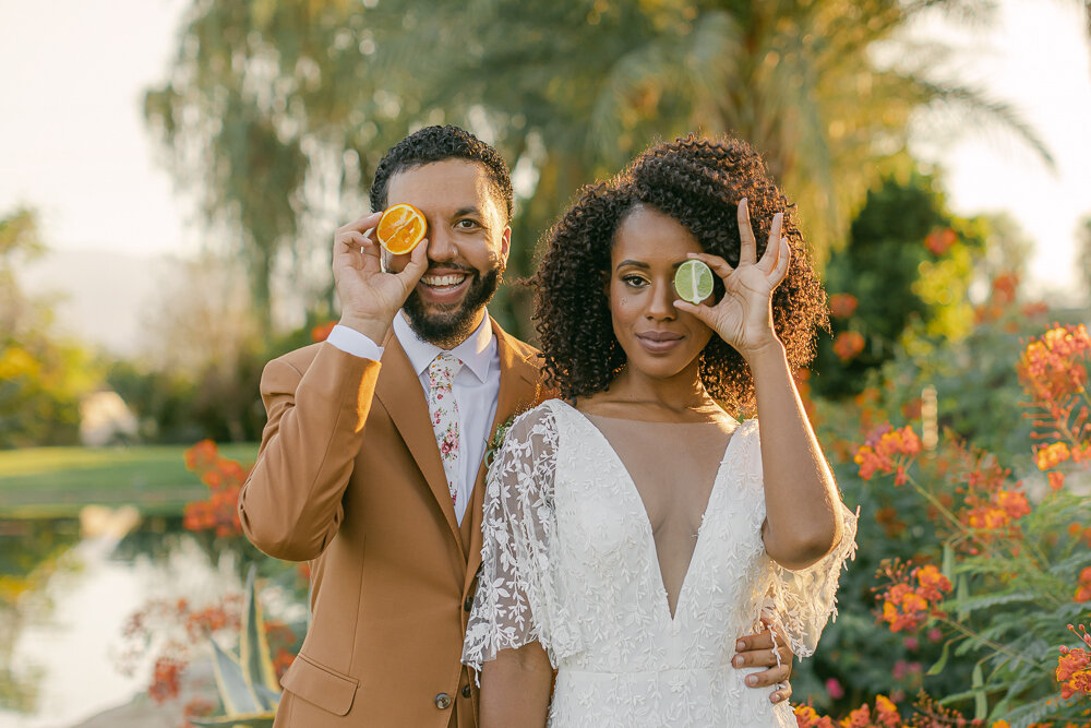 Couple holding fruit up to their face