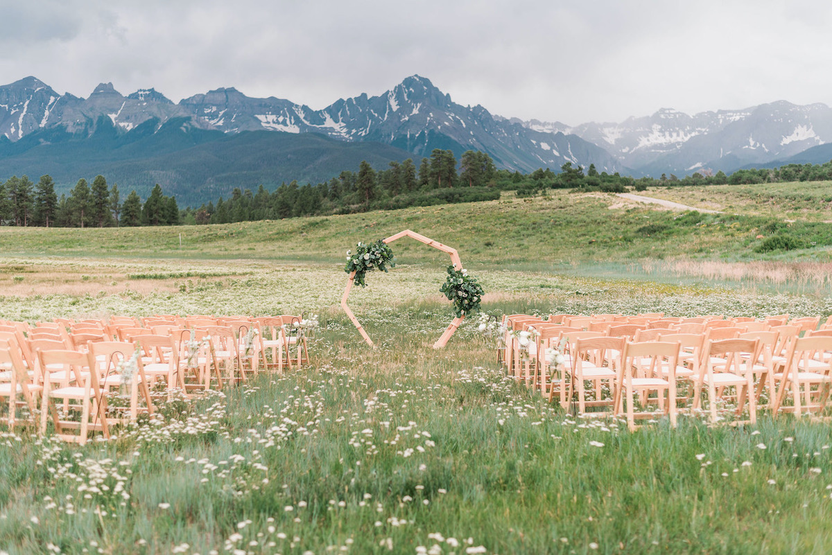 grassy knoll with wedding arch and chairs